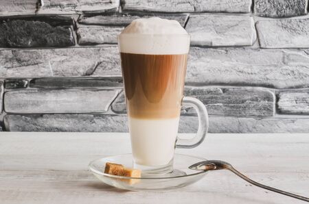 Delicious morning drink. Latte macchiato coffee on a white wooden table. の写真素材