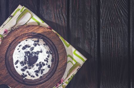 Delicious sweet snack served in a vintage style. Donut with a hole in white topping on dark wood.の写真素材