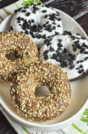 Sweet tasty dessert. Donuts with a hole, white chocolate and nuts.の写真素材