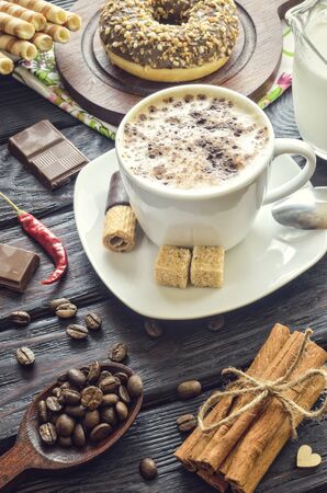 Elegant concept of serving coffee in vintage style. Coffee with foam and cinnamon with various sweets and decoration.の写真素材