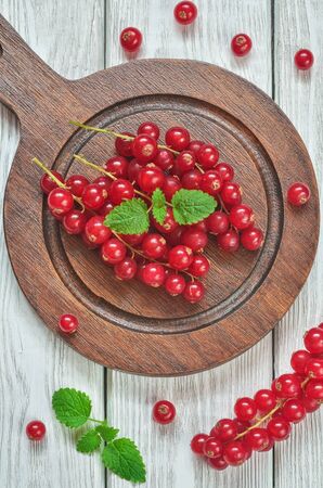 Red fruit in the kitchen. Red currant on a white wooden table.の写真素材