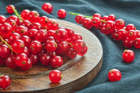 Red fruit in the kitchen. Red currant on a dark fabric background.の写真素材