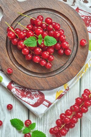 Red fruit in the kitchen. Red currant on a white wooden table.の写真素材