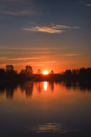 Wonderful morning landscape in Poland. The sun over the lake in a colorful sky.の写真素材