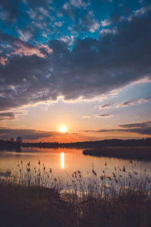 Wonderful morning landscape in Poland. The sun over the lake in a colorful sky.の写真素材