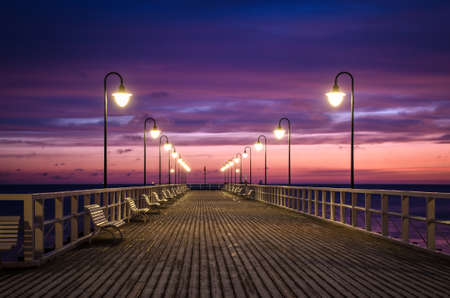 Beautiful morning seaside landscape. Wooden pier with a colorful sky in Gdynia Orlowo, Poland.の写真素材