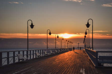 Beautiful morning seaside landscape. Wooden pier with a colorful sky in Gdynia Orlowo, Poland.の写真素材