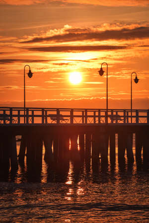Dreamlike sunrise over the Polish seaside. Beautiful morning sun over the pier in Gdynia, Poland.の写真素材
