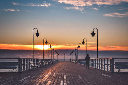 Beautiful morning seaside landscape. Wooden pier with a colorful sky in Gdynia Orlowo, Poland.の写真素材