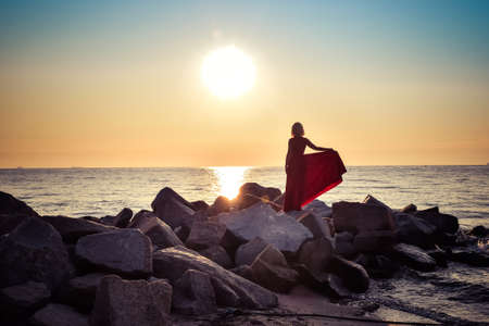 Beautiful seaside landscape with a woman on the beach. Girl in a red dress at the Polish seaside.の写真素材
