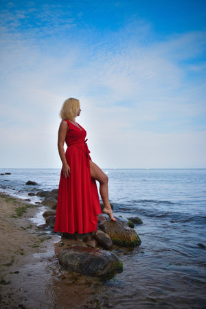 Summer concept with a beautiful woman. The blonde haired girl on the shore of the Polish sea.の写真素材