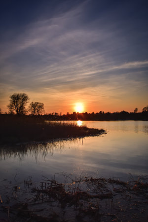 Beautiful summer landscape. The sun setting over the lake.の写真素材