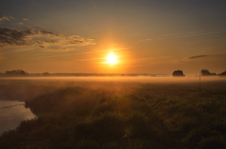 Beautiful morning foggy landscape. Sunrise over the river in Ponidzie in Poland.の写真素材