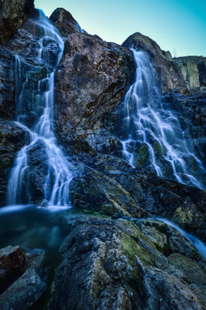 Beautiful waterfall with blurred water effect. Photo taken in the Valley of Five Ponds in the Polish Tatra Mountains. long-exposure photo.の写真素材