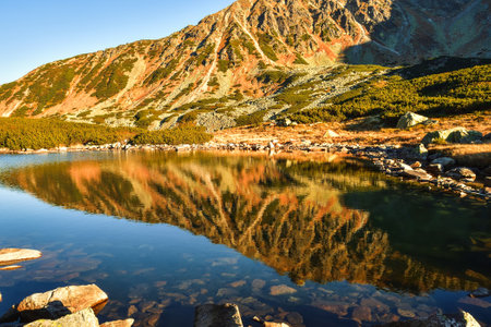 Beautiful summer mountain landscape. Mountain slopes reflecting in the lake. Photo taken in the Valley of Five Ponds in the Polish Tatra Mountains.の写真素材