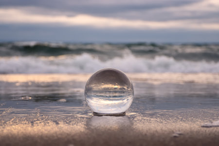 Abstract holiday seaside idea. Sea landscape held in a glass ball with a blurred background.の写真素材