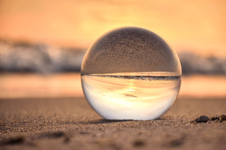 Abstract holiday seaside idea. Sea landscape held in a glass ball with a blurred background. Photo in shallow depth of field.の素材 [FY310199266810]