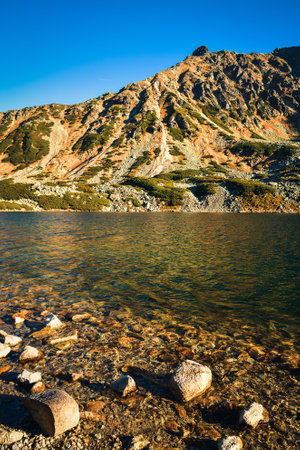 Beautiful summer mountain landscape. Mountain slopes reflecting in the lake. Photo taken in the Valley of Five Ponds in the Polish Tatra Mountains.の写真素材