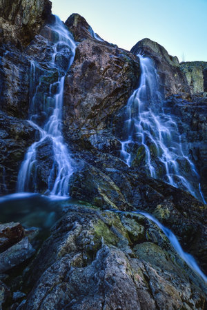 Beautiful waterfall with blurred water effect. Photo taken in the Valley of Five Ponds in the Polish Tatra Mountains. long-exposure photo.の写真素材