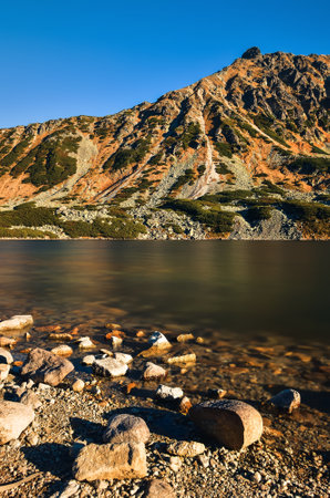 Beautiful summer mountain landscape. Mountain slopes reflecting in the lake. Photo taken in the Valley of Five Ponds in the Polish Tatra Mountains.の写真素材