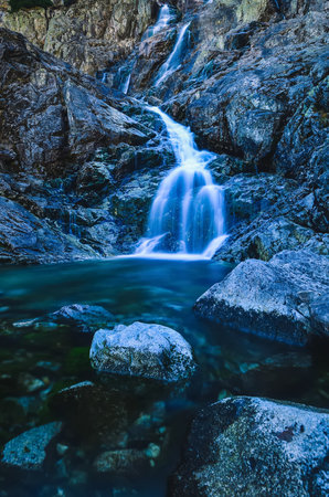 Beautiful waterfall with blurred water effect. Photo taken in the Valley of Five Ponds in the Polish Tatra Mountains. long-exposure photo.の写真素材