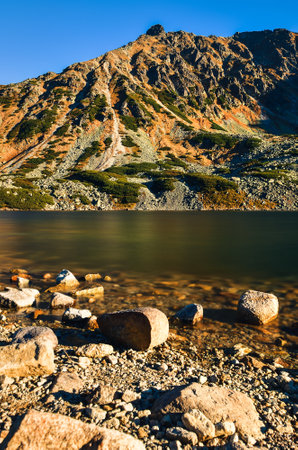 Beautiful summer mountain landscape. Mountain slopes reflecting in the lake. Photo taken in the Valley of Five Ponds in the Polish Tatra Mountains.の写真素材
