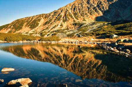 Beautiful summer mountain landscape. Mountain slopes reflecting in the lake. Photo taken in the Valley of Five Ponds in the Polish Tatra Mountains.の写真素材