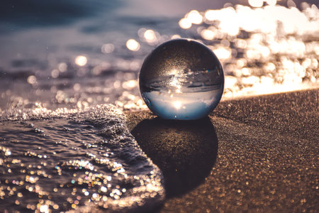 Abstract idea with water with an interesting effect. Glass ball on a blurred background on a seaside beach in Gdynia, Poland. Photo with a shallow depth of field.の写真素材