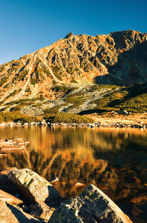 Beautiful summer mountain landscape. Mountain slopes reflecting in the lake. Photo taken in the Valley of Five Ponds in the Polish Tatra Mountains.の写真素材