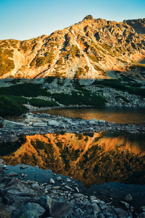 Beautiful summer mountain landscape. Mountain slopes reflecting in the lake. Photo taken in the Valley of Five Ponds in the Polish Tatra Mountains.の写真素材