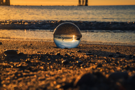 Abstract idea with water with an interesting effect. Glass ball on a blurred background on a seaside beach in Gdynia, Poland. Photo with a shallow depth of field.の写真素材