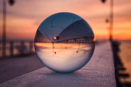 Abstract idea with water with an interesting effect. Glass ball on a blurred background on a seaside beach in Gdynia, Poland. Photo with a shallow depth of field.の写真素材