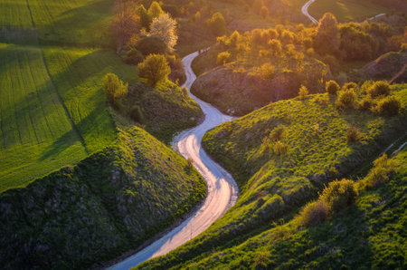 Beautiful spring landscape among green hills. Charming winding road between green nature. Photo taken in Grodzisko - Stradow, Poland.の写真素材
