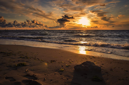 Beautiful dreamlike morning on the Baltic Sea in Gdynia, Poland. Stones on the beach in the glow of the rising sun.の写真素材