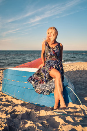 Beautiful holiday concept with a woman on the beach. Girl on a boat in Jastarnia, Poland.の写真素材