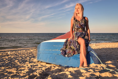 Beautiful holiday concept with a woman on the beach. Girl on a boat in Jastarnia, Poland.の写真素材