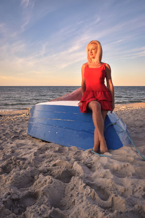 Beautiful holiday concept with a woman on the beach. Girl on a boat in Jastarnia, Poland.の写真素材