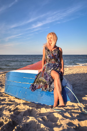 Beautiful holiday concept with a woman on the beach. Girl on a boat in Jastarnia, Poland.の写真素材