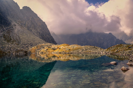 Summer mountain landscape in Slovak Tatra Mountains. Beautiful lake and mountain rocky peaks in the clouds.の写真素材
