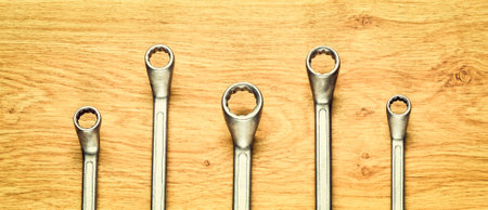 Group of wrenches on a wooden table. Wrenches in several different sizes on natural wooden background.の写真素材