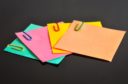 Colored sticky notes with paper clips. Concept for taking notes on cards.