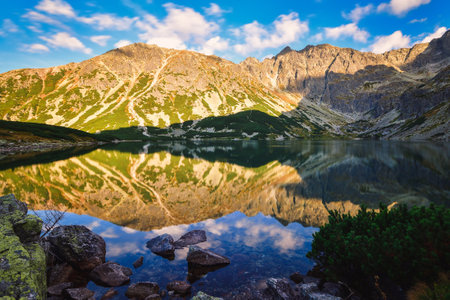 Beautiful summer mountain landscape by the lake. View of the mountains reflecting in the water at Czarny Staw Gasienicowy in the Polish High Tatras.の写真素材