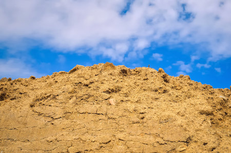Stockpile of sand. Pile of sand with blue sky at background.の写真素材