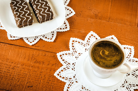 Table setting with cookies with chocolate and coffee drink. Coffee and cakes in chocolate sauce on a wooden table. Photo with a shallow depth of field.の写真素材