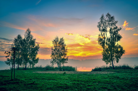 Foggy colorful morning on the lake. Sunrise over Lake Paproacany in Tychy, Poland.の写真素材