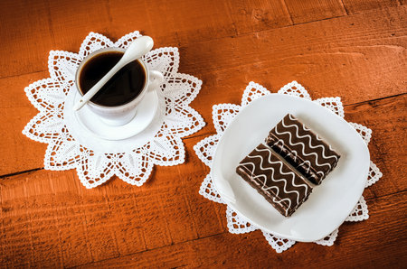 Table setting with cookies with chocolate and coffee drink. Coffee and cakes in chocolate sauce on a wooden table.の写真素材