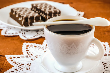 Table setting with cookies with chocolate and coffee drink. Coffee and cakes in chocolate sauce on a wooden table. Photo with a shallow depth of field.の写真素材