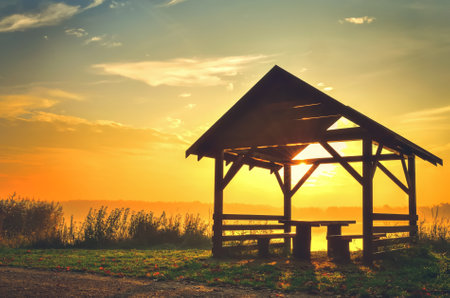 Autumn morning landscape. Wooden shelter on the lake at sunrise.の写真素材
