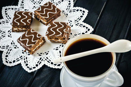 Table setting with cookies with chocolate and coffee drink. Coffee and cakes in chocolate sauce on a wooden black table.の写真素材