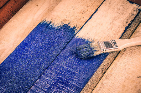 Brush, paint and wooden boards. Painting the boards with blue paint.の写真素材
